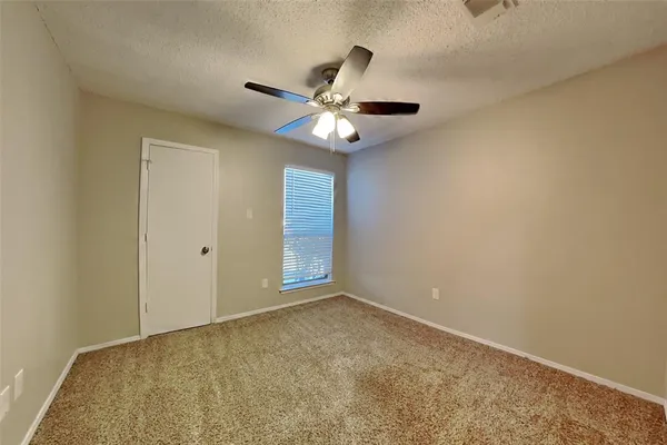 a view of an empty room and a chandelier fan