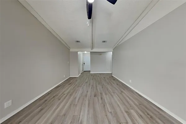 a view of empty room with wooden floor