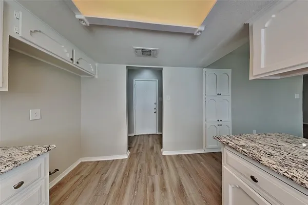 a kitchen with cabinets and wooden floor