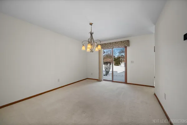 a kitchen with stainless steel appliances granite countertop a stove a refrigerator a kitchen island a stove a dining table and chairs with wooden floor