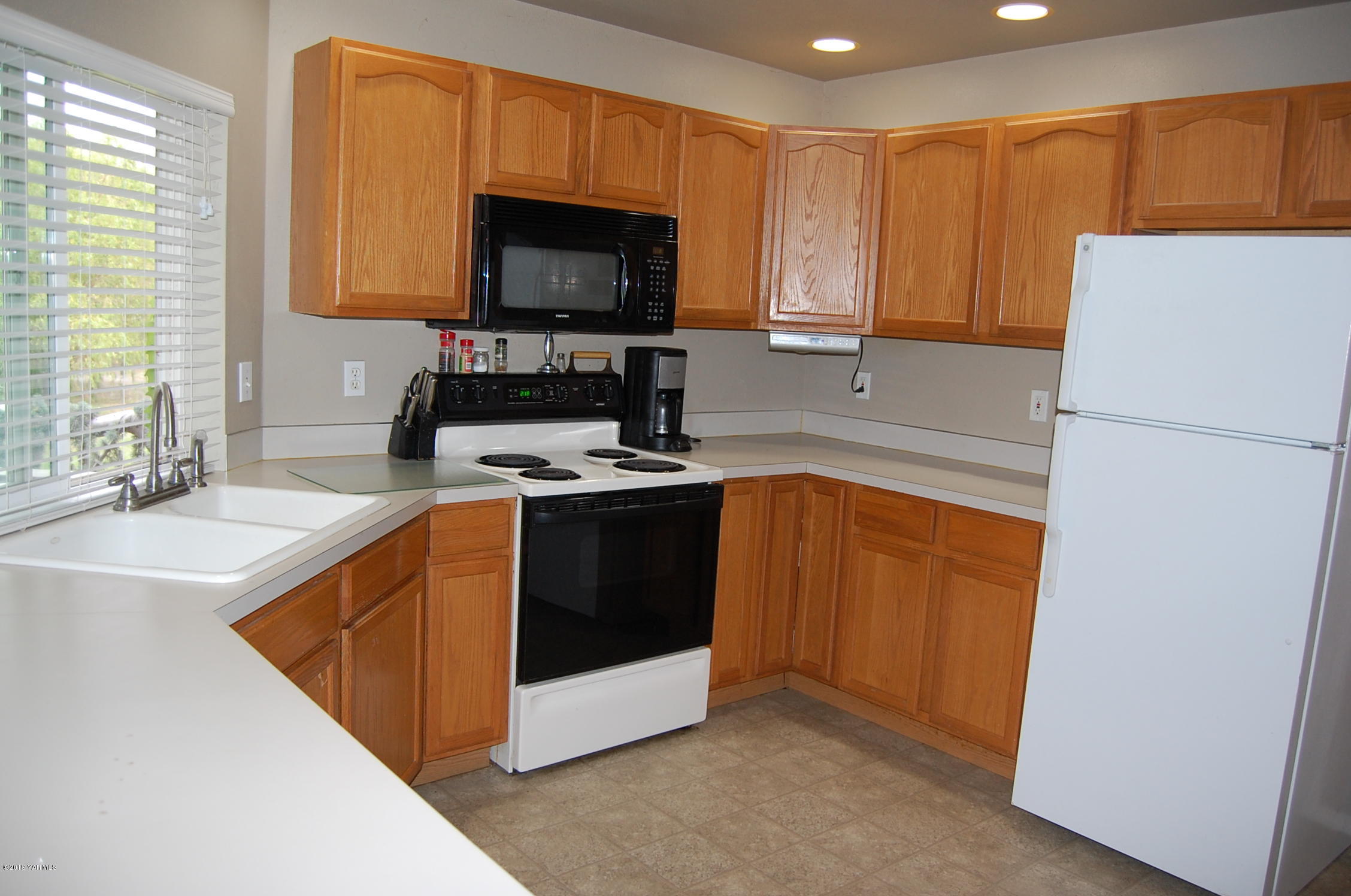 15021 Douglas Road Yakima, WA 98908 - Photo 8 of 35 a kitchen with sink a microwave a refrigerator and cabinets