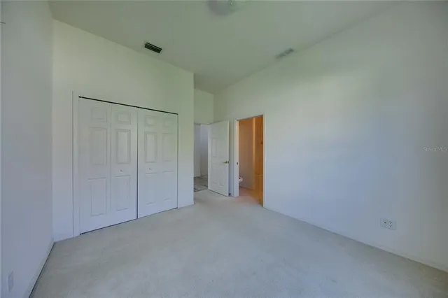 an empty room with windows and closet