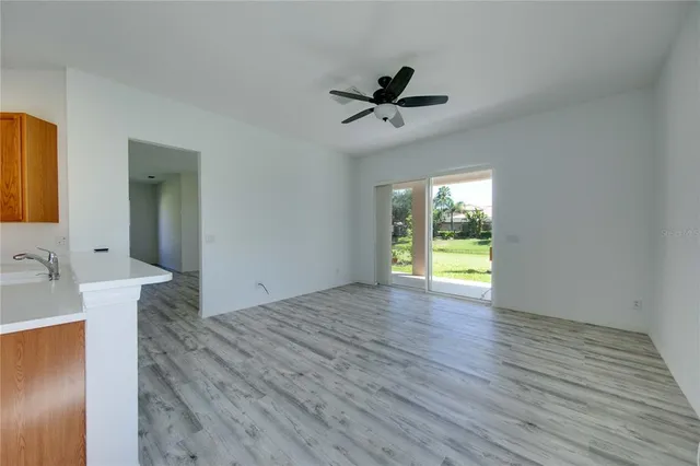 a view of an empty room with window and wooden floor