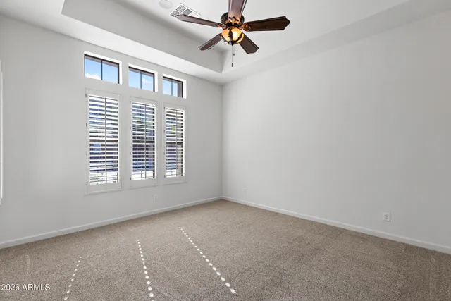 an empty room with windows and fan