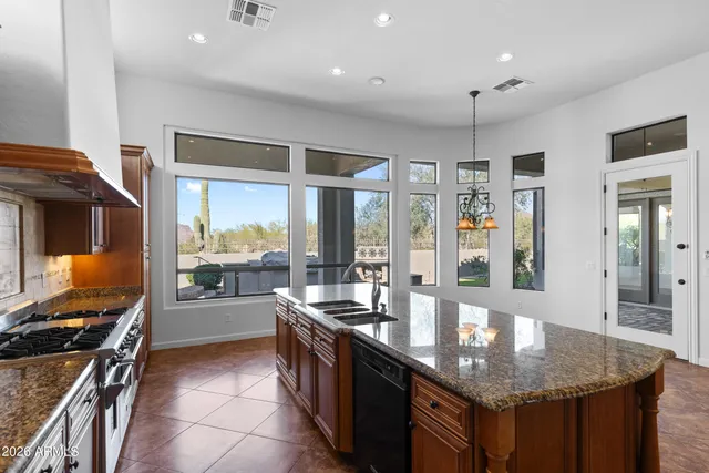 a kitchen with granite countertop a sink and a stove