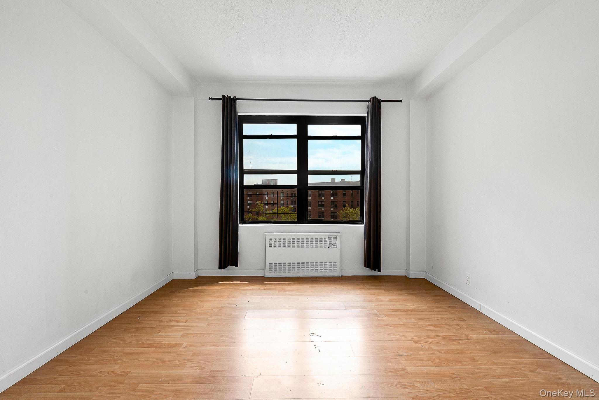 99-32 66th Road, Unit 5B Queens, NY 11374 - Photo 20 of 27 Unfurnished room featuring radiator and light wood finished floors