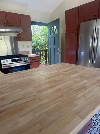 a kitchen with stainless steel appliances a stove refrigerator and cabinets