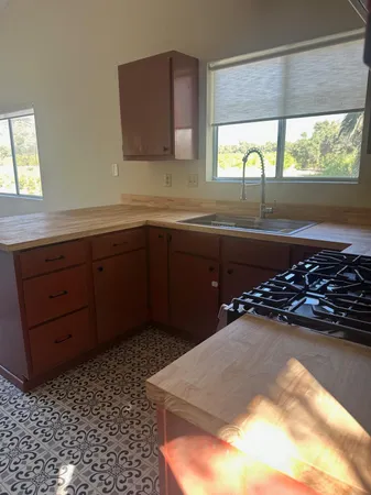 a kitchen with a sink a stove and a wooden cabinets