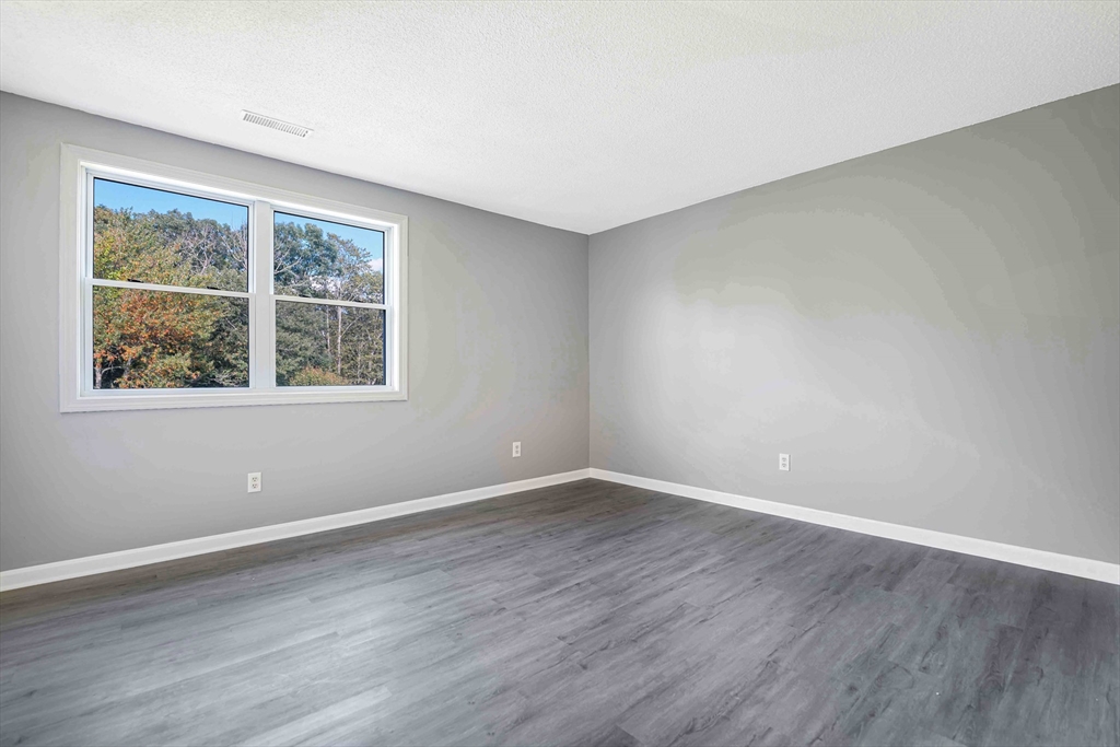 1475 Braley Road, Unit 22 New Bedford, MA 02745 - Photo 12 of 19 a view of an empty room with wooden floor and a window