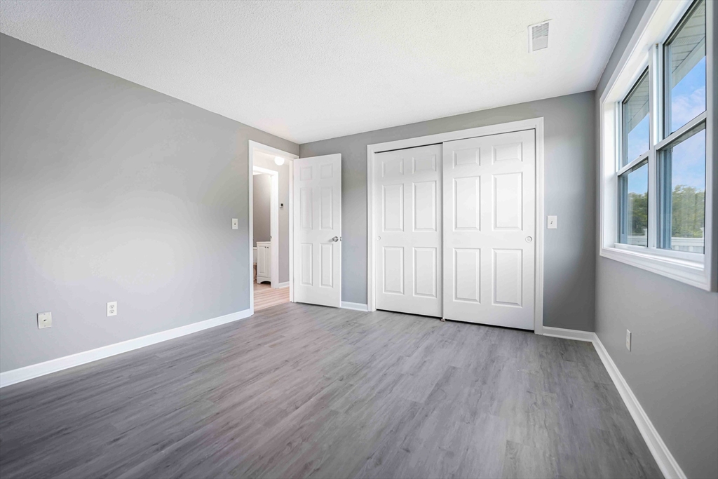 1475 Braley Road, Unit 22 New Bedford, MA 02745 - Photo 13 of 19 a view of an empty room with wooden floor and a window
