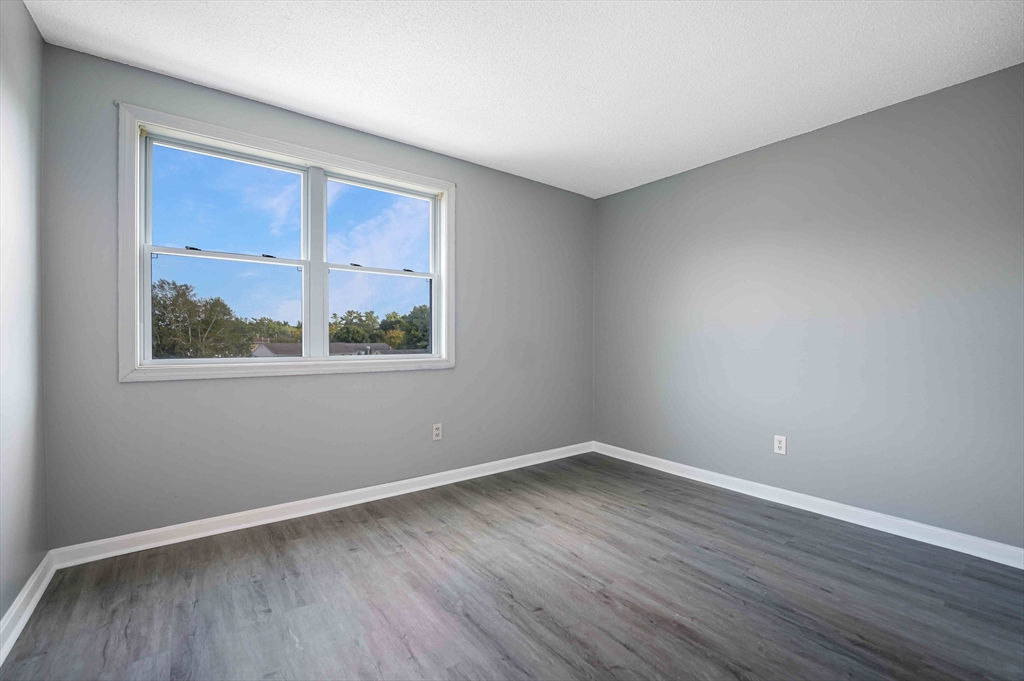 1475 Braley Road, Unit 22 New Bedford, MA 02745 - Photo 16 of 19 a view of an empty room with wooden floor and a window