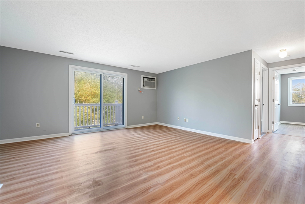 1475 Braley Road, Unit 22 New Bedford, MA 02745 - Photo 7 of 19 a view of an empty room with wooden floor and a window