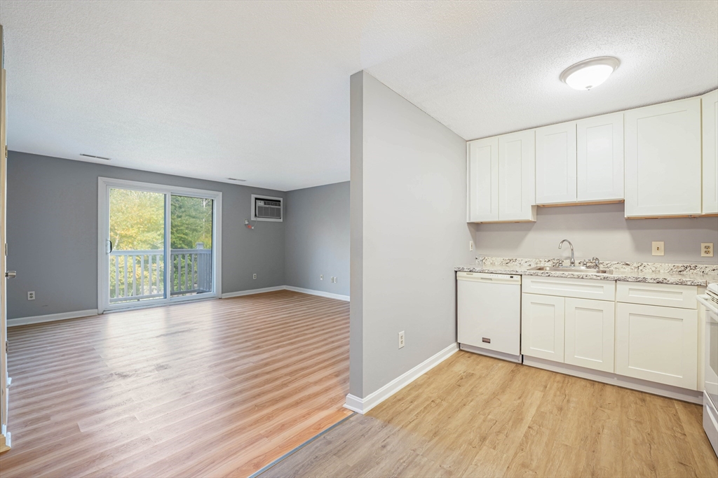 1475 Braley Road, Unit 22 New Bedford, MA 02745 - Photo 9 of 19 a view of a kitchen with wooden floor and a window