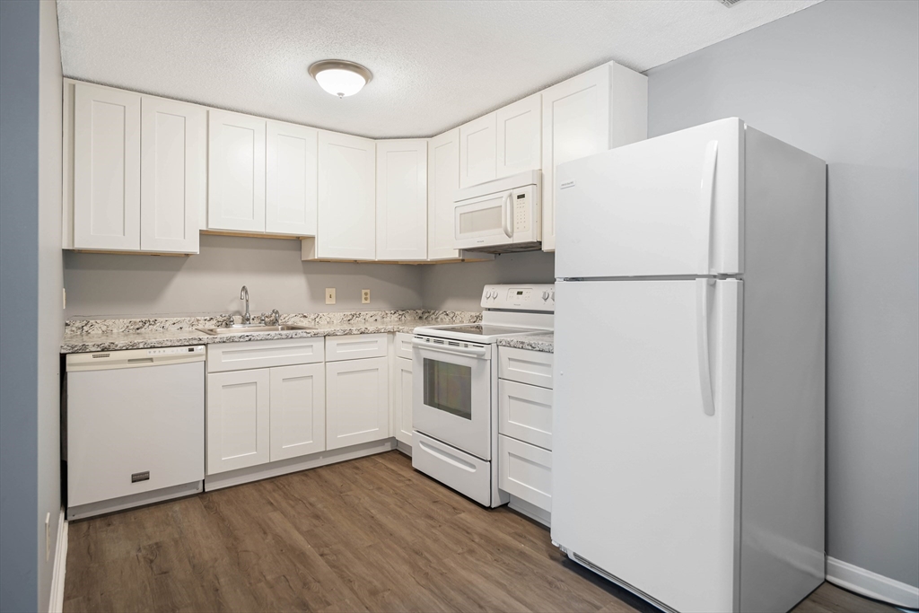 1475 Braley Road, Unit 22 New Bedford, MA 02745 - Photo 10 of 19 a kitchen with white cabinets and white appliances