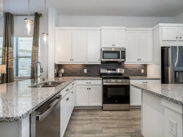 a kitchen with white cabinets and stainless steel appliances