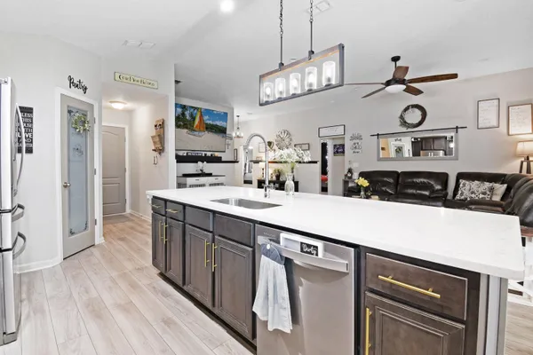 a kitchen with kitchen island granite countertop a sink and refrigerator