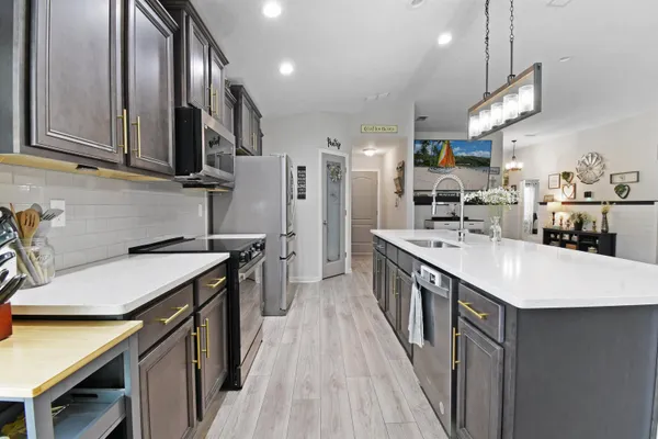 a kitchen with stainless steel appliances granite countertop a sink a stove and a refrigerator