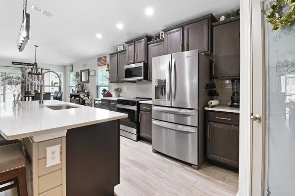a kitchen with kitchen island a sink appliances and cabinets