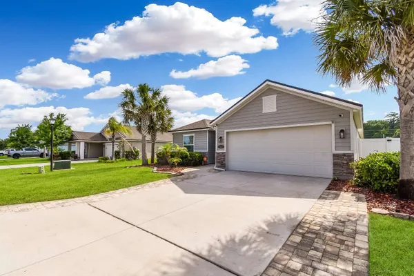 a front view of a house with a garden and trees
