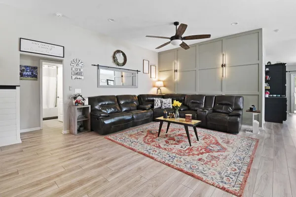a living room with furniture a rug and wooden floor