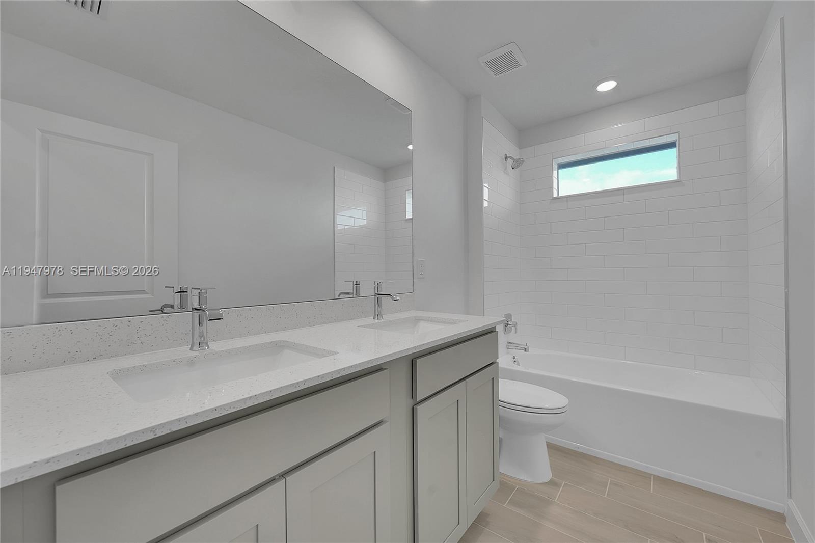 19560 Whispering Creek Road, Unit 19560 Loxahatchee, FL 33470 - Photo 11 of 19 a bathroom with a granite countertop sink a toilet and bathtub