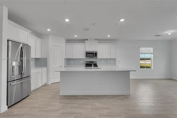 a large kitchen with stainless steel appliances a refrigerator and a stove top oven