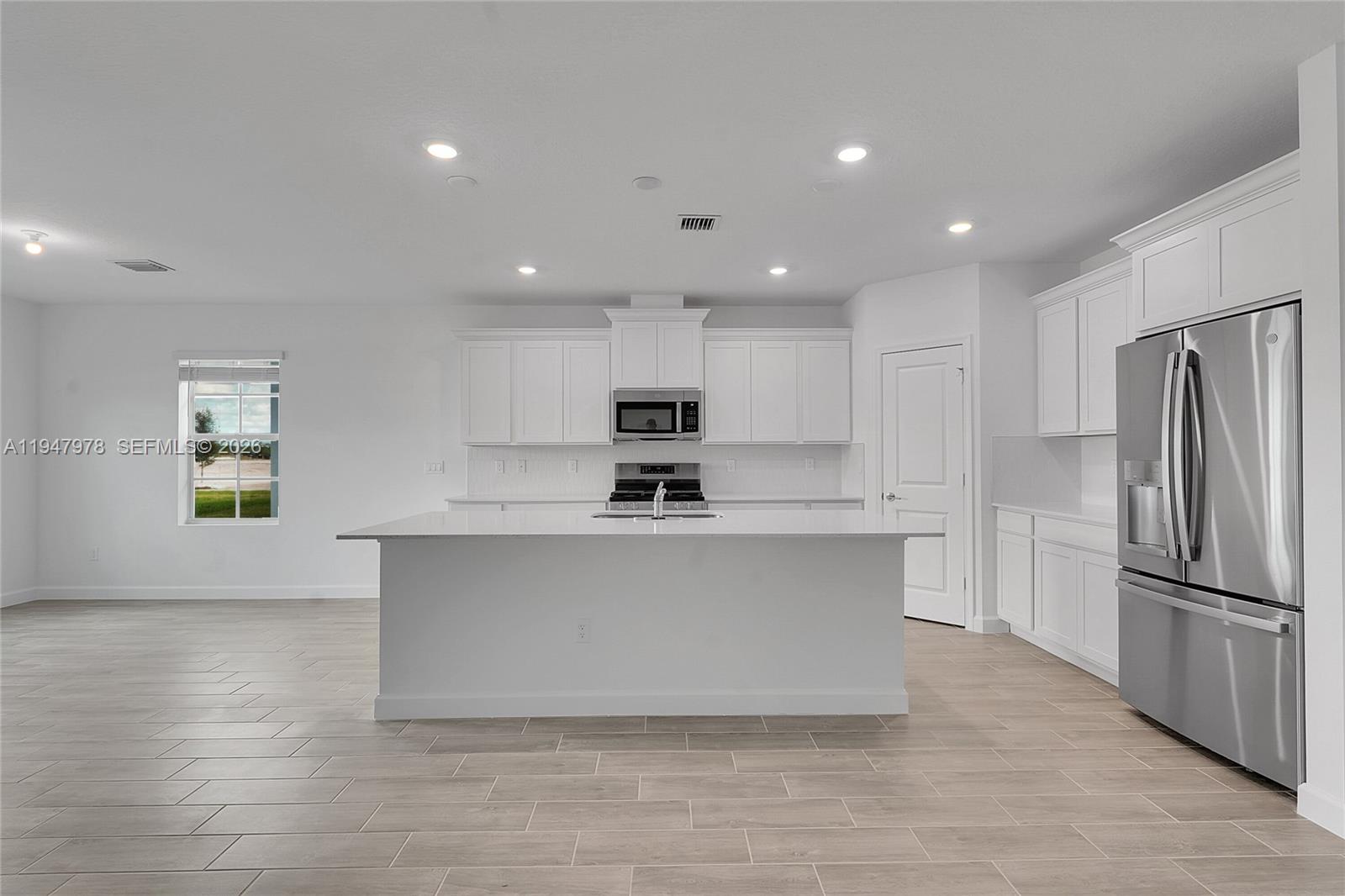 19560 Whispering Creek Road, Unit 19560 Loxahatchee, FL 33470 - Photo 4 of 19 a kitchen with stainless steel appliances a refrigerator sink and white cabinets