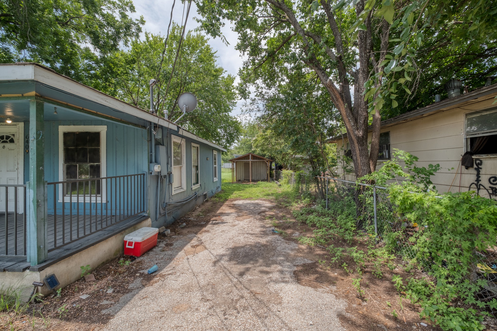 6409 Del Monte Road Austin, TX 78741 - Photo 4 of 15 A modest side yard connects two structures, offering potential for outdoor enjoyment.
