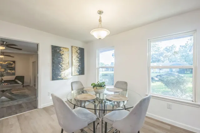 a view of a dining room with furniture wooden floor and a chandelier
