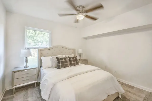 a bedroom with a bed and a ceiling fan
