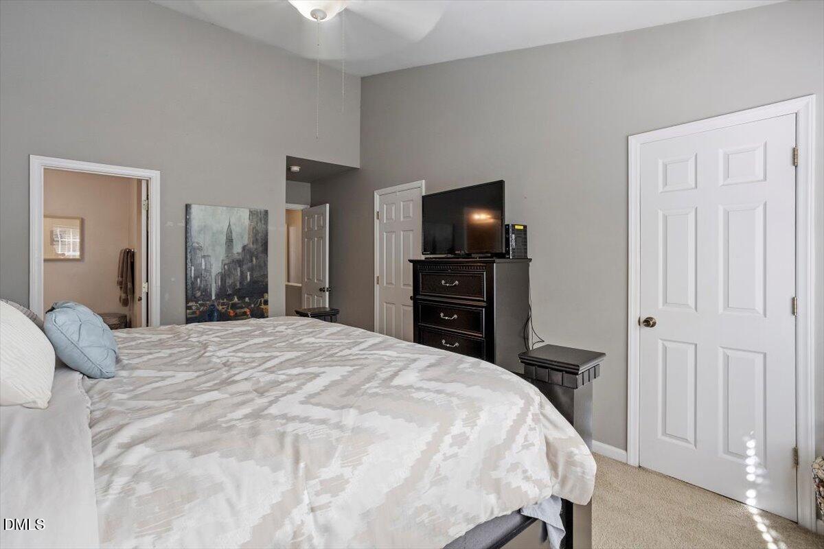 5710 Corbon Crest Lane Raleigh, NC 27612 - Photo 18 of 25 a bedroom with a bed and a flat tv screen tv on the dresser