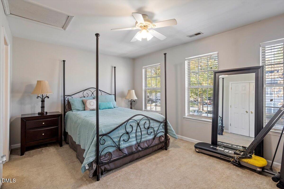 5710 Corbon Crest Lane Raleigh, NC 27612 - Photo 21 of 25 a bedroom with a bed a dresser and a window