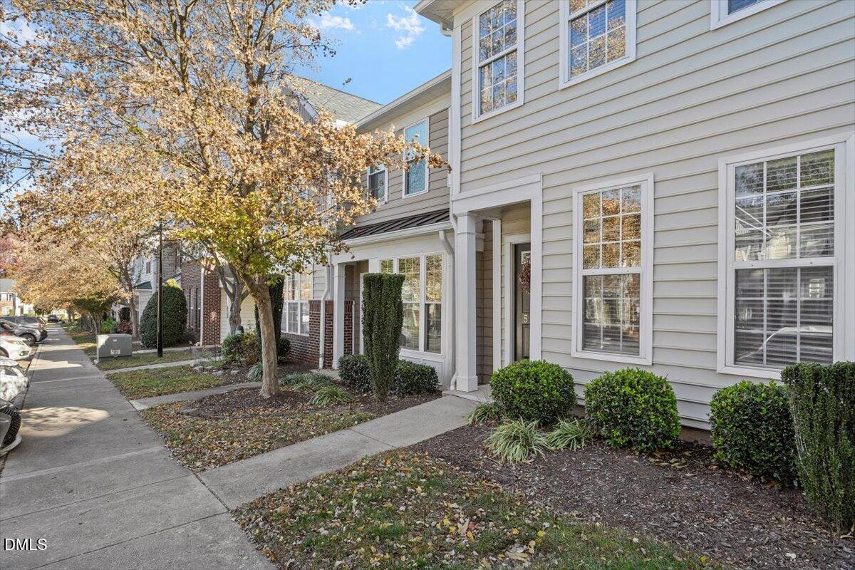 5710 Corbon Crest Lane Raleigh, NC 27612 - Photo 3 of 25 a view of a brick house with many windows next to a yard