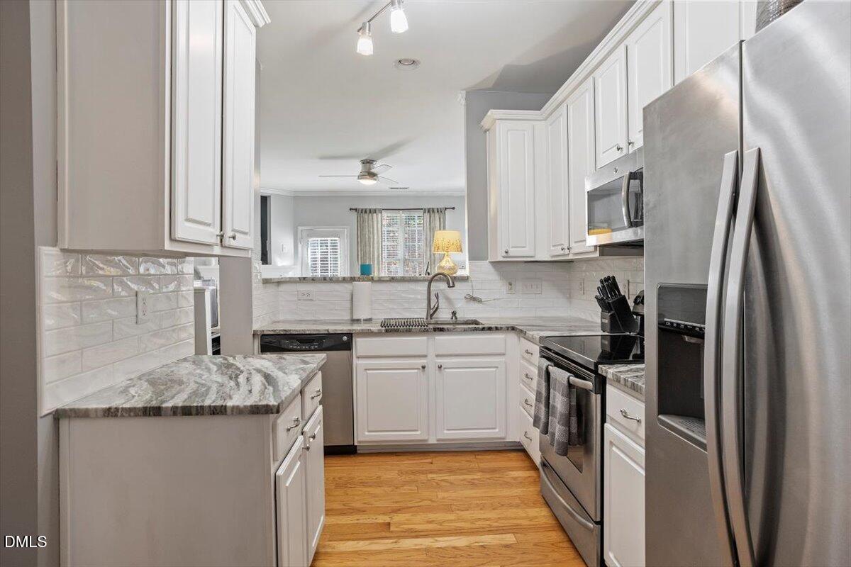 5710 Corbon Crest Lane Raleigh, NC 27612 - Photo 8 of 25 a kitchen with stainless steel appliances granite countertop a sink stove and refrigerator