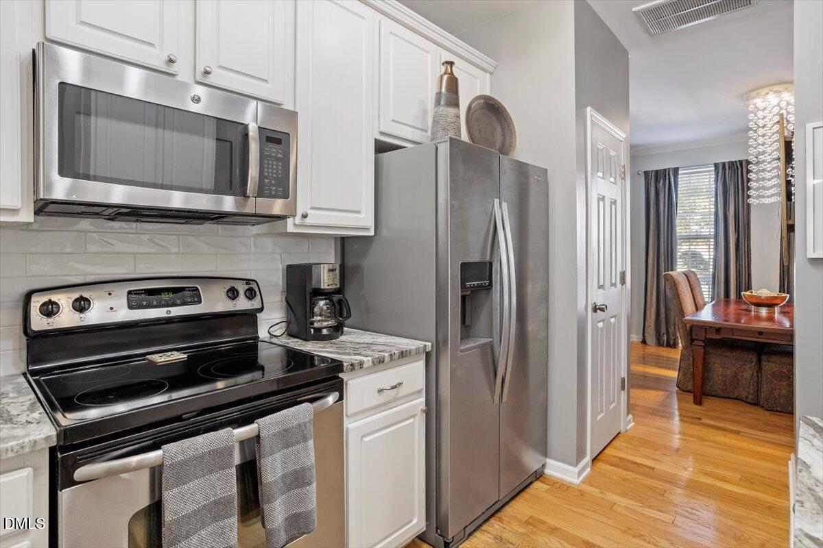 5710 Corbon Crest Lane Raleigh, NC 27612 - Photo 9 of 25 a kitchen with stainless steel appliances a stove a microwave and a refrigerator