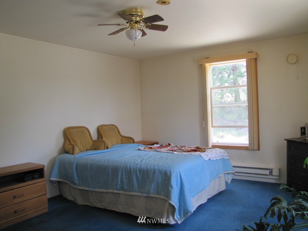 40 Main Road Tonasket, WA 98855 - Photo 14 of 25 a bedroom with a bed a chandelier and a window