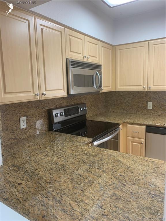 3129 Southeast Indian Street, Unit 3 Stuart, FL 34997 - Photo 4 of 10 a kitchen with granite countertop a sink stove and microwave