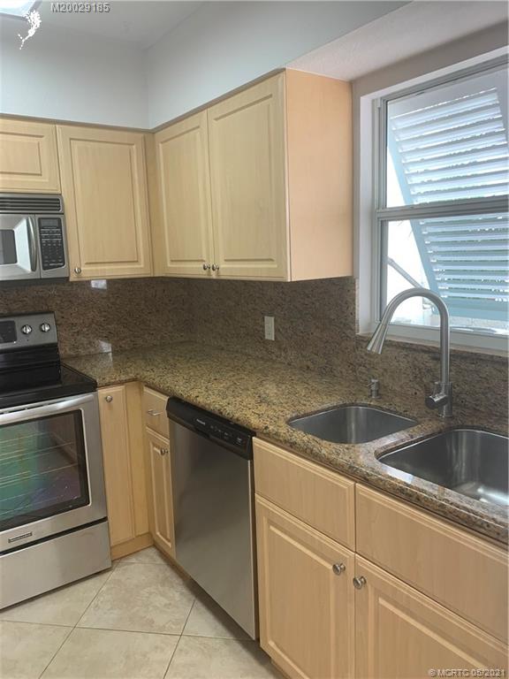 3129 Southeast Indian Street, Unit 3 Stuart, FL 34997 - Photo 5 of 10 a kitchen with granite countertop a sink and a stove