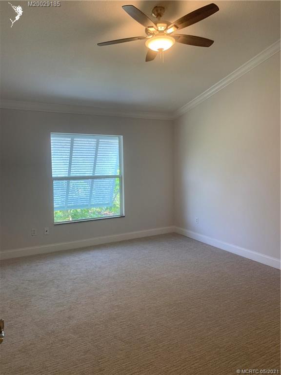 3129 Southeast Indian Street, Unit 3 Stuart, FL 34997 - Photo 9 of 10 an empty room with a window and ceiling fan