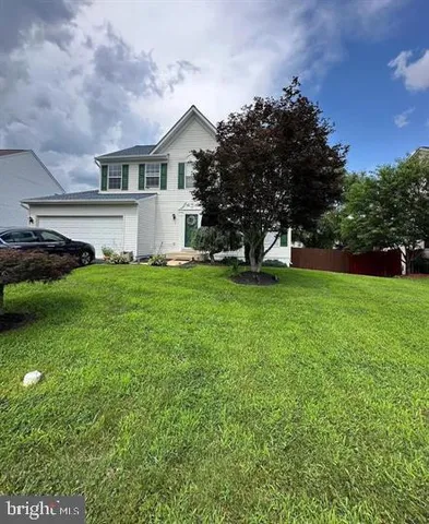 a view of a house with a big yard and large trees