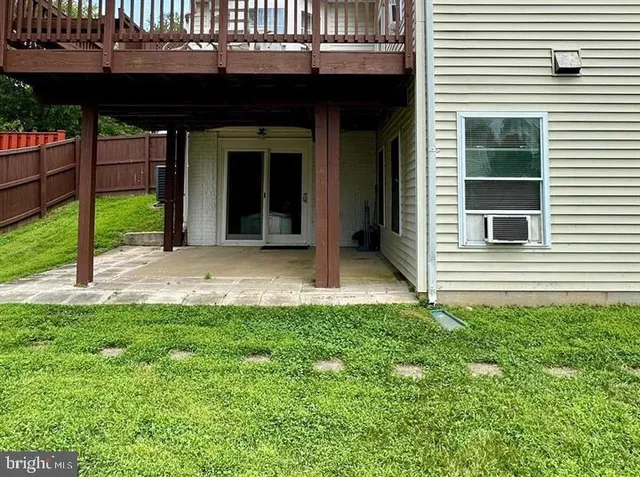 a view of backyard with a deck and a large tree