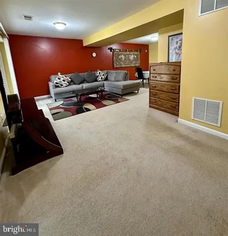 a living room with furniture and a ceiling fan