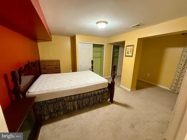 a bed sitting in a spacious bedroom next to a window