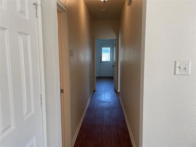 a view of a hallway with wooden floor