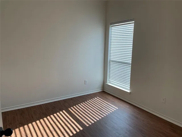a view of a room with wooden floor and a window
