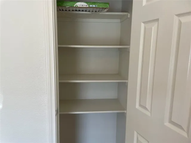 a view of walk in closet with empty racks