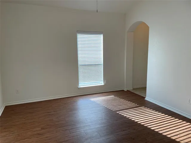 a view of a room with wooden floor and a window