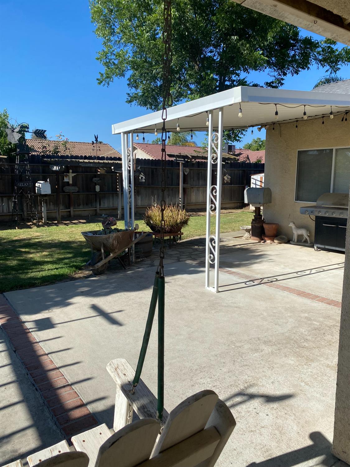 609 Merlot Avenue Madera, CA 93637 - Photo 35 of 45 a view of a patio with table and chairs a barbeque with wooden fence