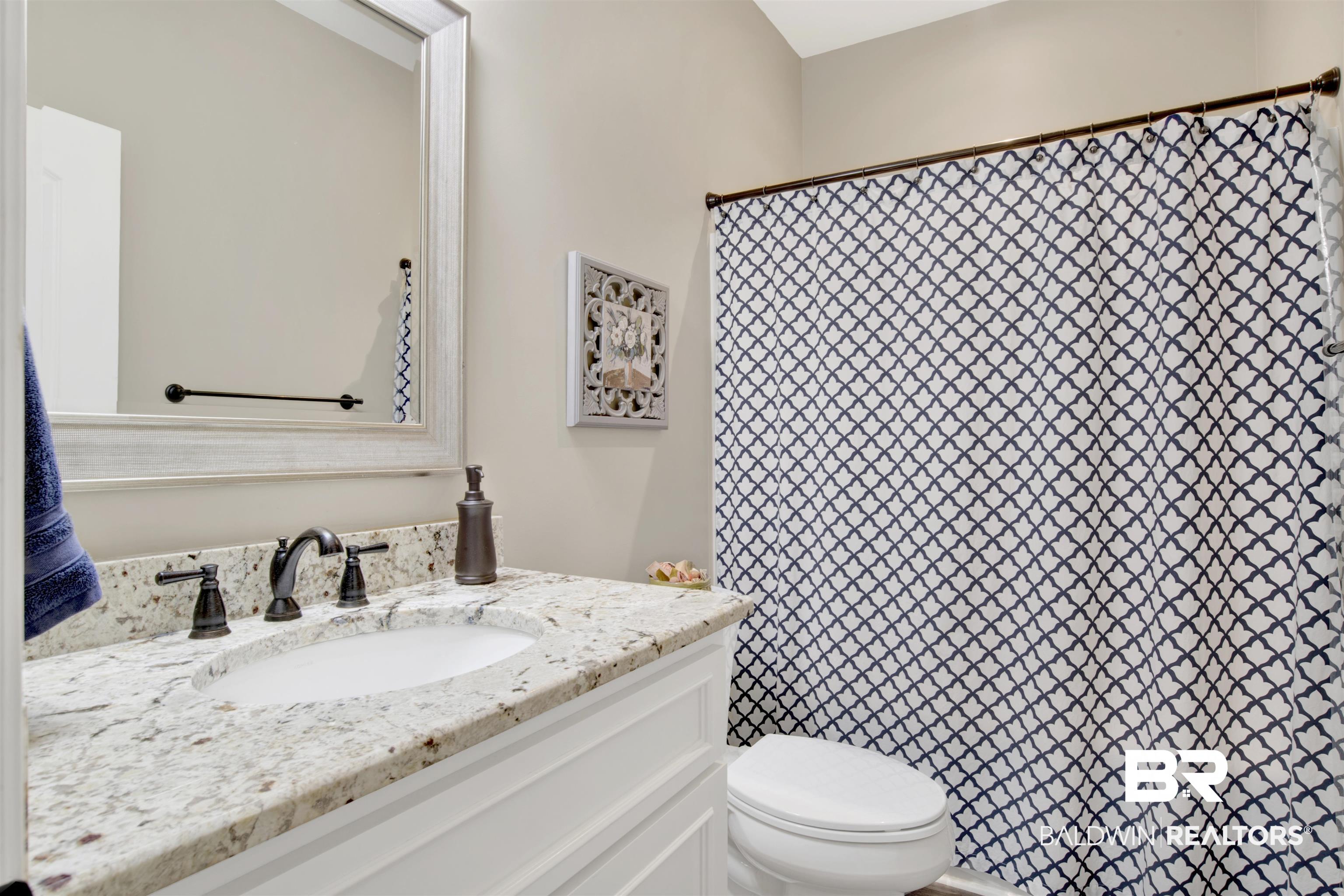 2440 Johnson Road West Mobile, AL 36695 - Photo 26 of 40 Bathroom featuring a shower with shower curtain, vanity, and toilet