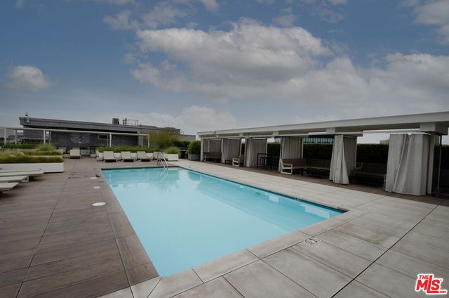a view of a swimming pool with outdoor seating and a yard